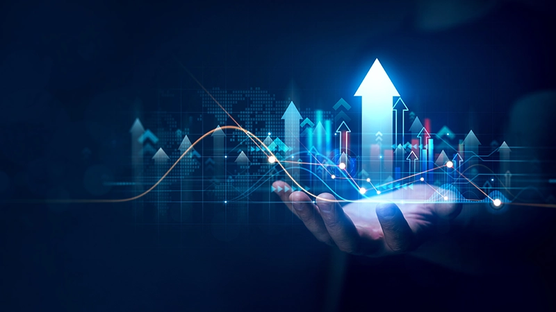 A hand holding a glowing display of upward-trending financial charts, graphs and a business representation of growth, success, or data analysis.